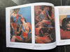 Open book displaying art illustrations of women with tattoos on a dark surface